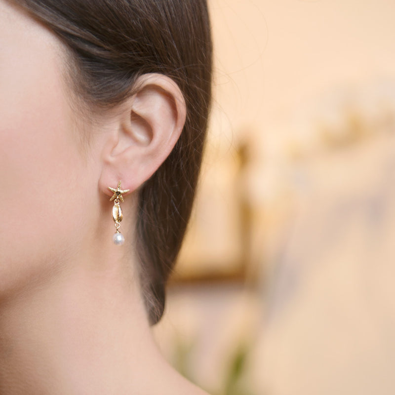 Model Wearing Starfish Cowrie Drop Earrings in 18ct Gold
